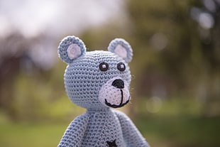 close up selective focus photo of knitted bear amigurumi plush toy