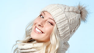 woman with blonde hair wearing white knit cap