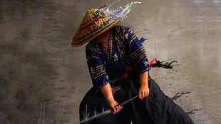 samurai holding katana and wearing brown and purple hat