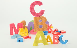 person showing multicolored rubber alphabet print mats