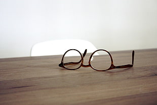 black framed eyeglasses on brown table