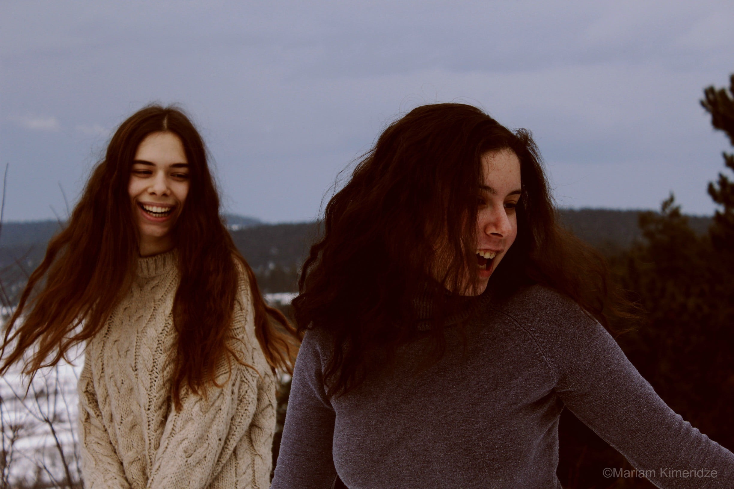 two woman in gray and black sweaters