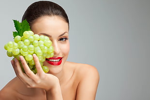 woman holding green grape
