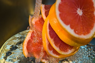 poured water with sliced yellow fruits in tilt shift lens photography, pink grapefruit