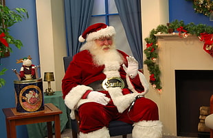 man wearing Santa Claus costume sitting on chair HD wallpaper