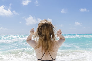 woman wearing bra in front of body of water