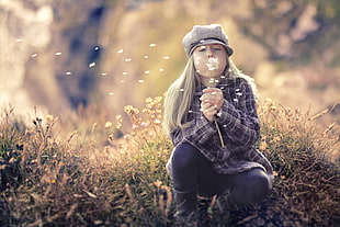 girl wearing black jeans blowing white flower in tilt shift lens photogtraphy