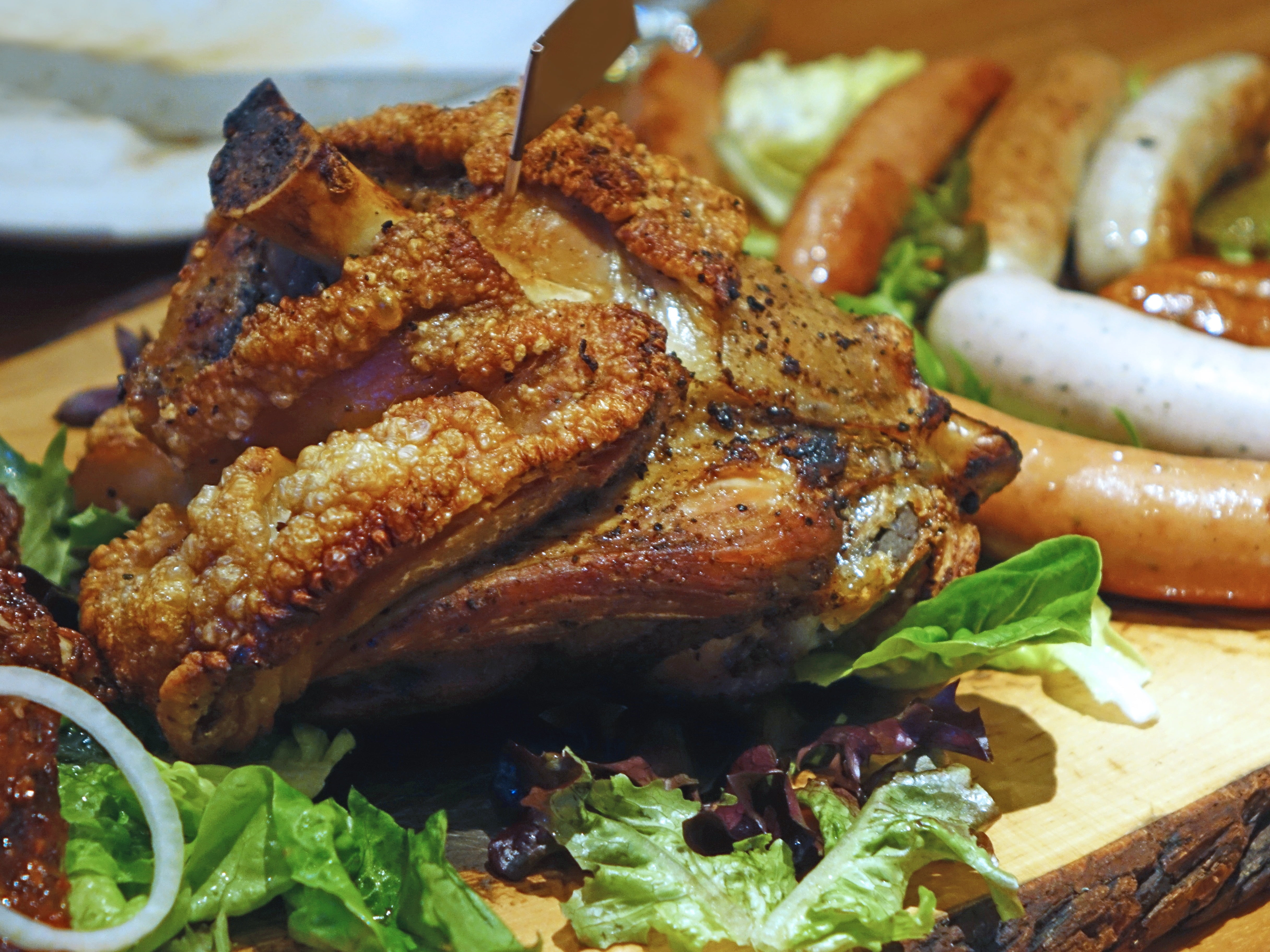 fried meat beside sausages with green vegetables