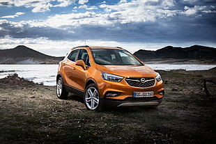 orange Opel 5-door hatchback HD wallpaper