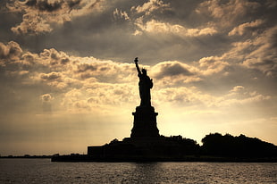 Statue of Liberty silhouette during golden hour HD wallpaper