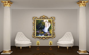 two white leather sofa chairs beside each other with waterfall artwork in white painted room