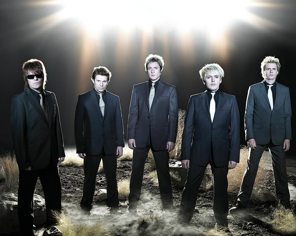 5-man band wearing black suits with lighted background HD wallpaper