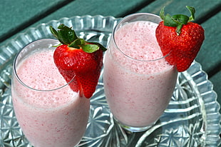 two clear drinking glasses with strawberry shake