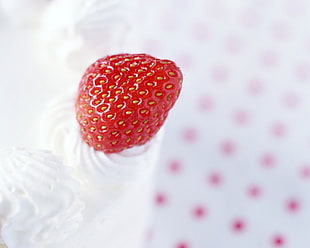 red strawberry on white icing cupcake