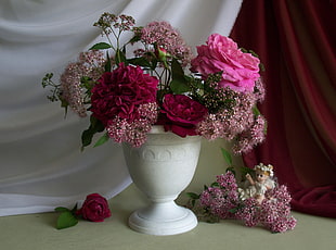 red and pink petaled flowers arrangement on white vase