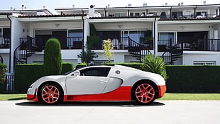 white and red coupe near white concrete storey building