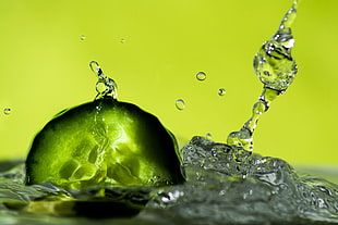 close  up photography of water drop splash, cucumber