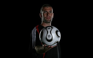 soccer player holding white adidas soccer ball