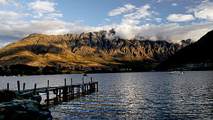 brown wooden dock on water towards mountain