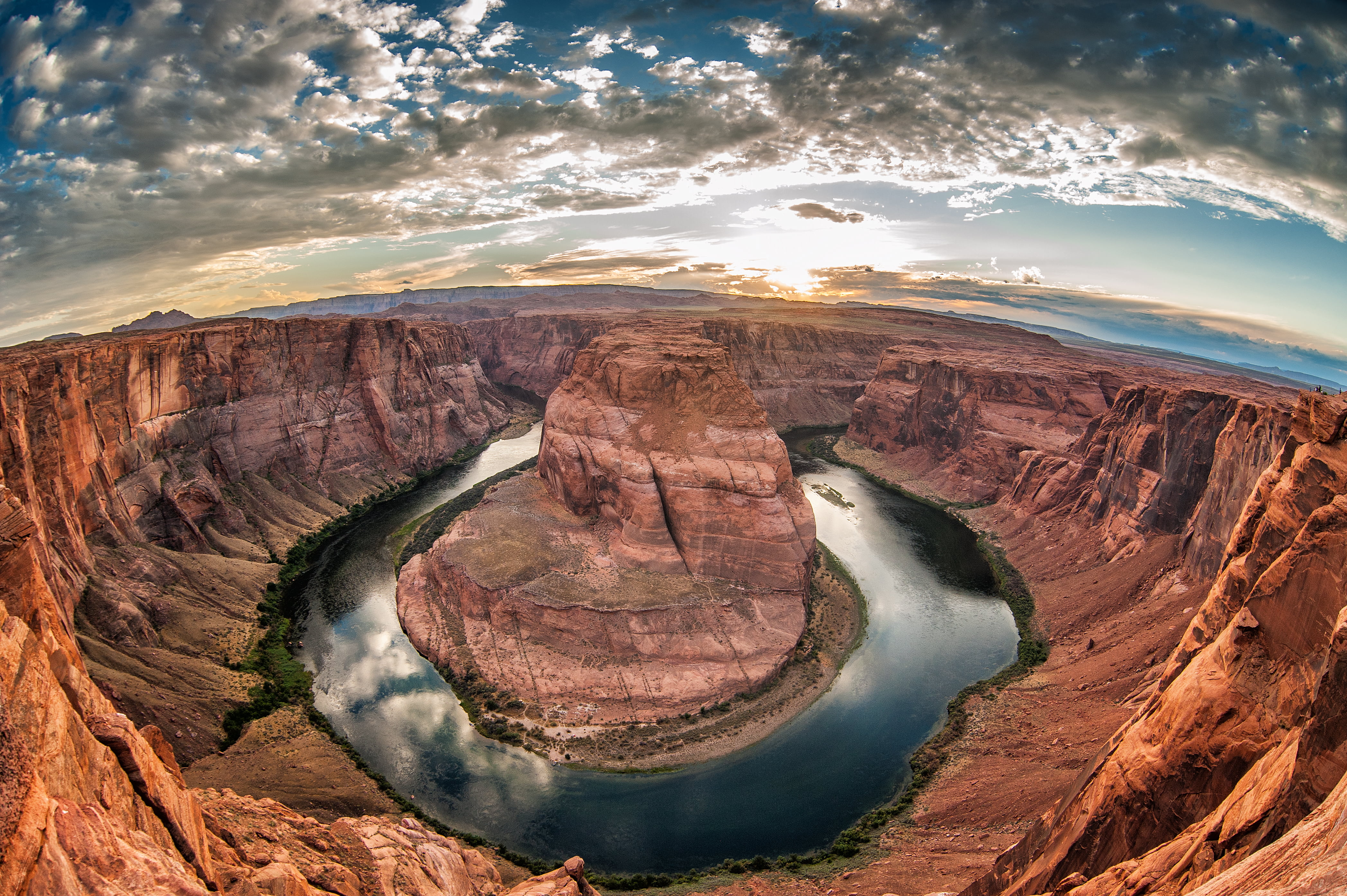 brown rock formation surrounded by body of water over horizon