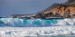 body of water and rock formation during daytime