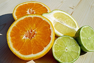 Slice Orange, Lemon and Calamansi on brown wooden table