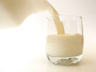 clear drinking glass filled with milk