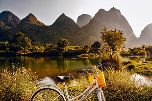white cruiser bicycle beside the lake