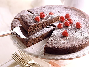 brown cake with raspberry toppings