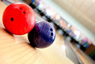 tilt shift photography of two red and blue bowling balls