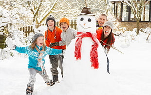 group of people standing next to snowman