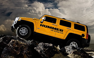 yellow Hummer SUV on rock HD wallpaper