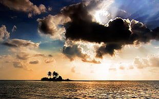 black clouds covering sun and island silhouette photo