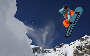 man wearing orange and blue on snowboard