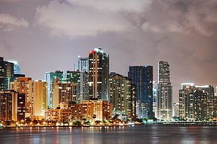 high rise buildings beside body of water under cloudy sky during nighttime, miami