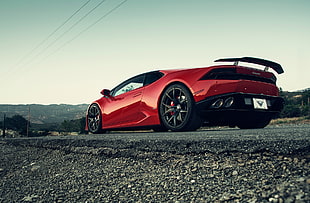 red Lamborghini Huracan on pavement HD wallpaper
