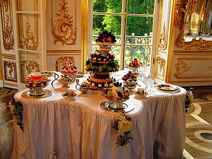 plates, cups, and cake table setting on top of white table near window