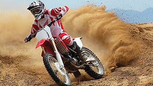 person riding red and white motocross bike
