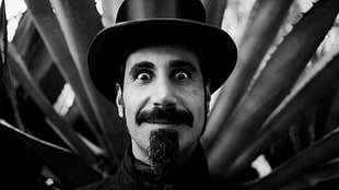 grayscale photo of bearded man wearing top hat