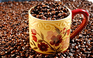 Beans of Coffee on yellow and red ceramic mug