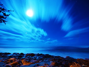 time lapse photography of sky and body of water during night time HD wallpaper