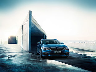 blue BMW car near gray concrete wall