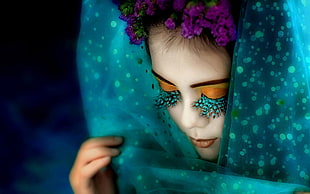 woman with polka dot scarf and green false eyelashes