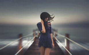 timelapse photograph of woman walking on dock