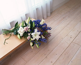 photo of purple, green, and white bouquet flowers on brown surface