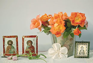 orange petaled roses in a clear glass vase