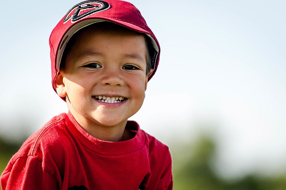selective focus photography of boy wearing red cap HD wallpaper