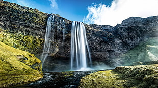 landscape photography of waterfalls under blue sky and white clouds