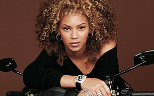 closeup photo of Beyonce in black bracelet-sleeve blouse riding motorcycle