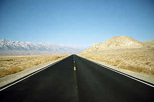 black asphalt road through rocky mountain